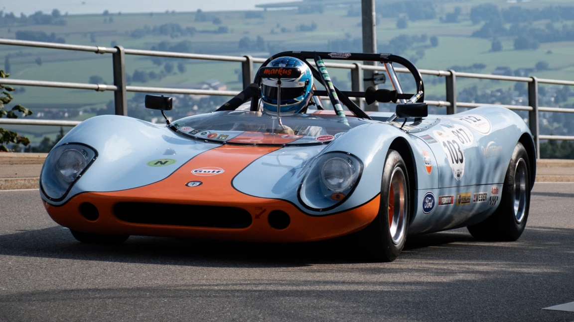 Rennwagen bei einer Veranstaltung im Freien Leichter Rennwagen mit orange-blauer Lackierung auf Straße