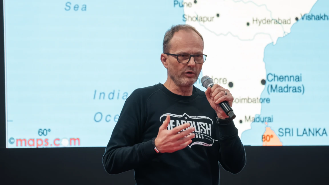 Mann in schwarzem Sweatshirt spricht w&auml;hrend Vortrag auf der Motorradwelt 2026 in Friedrichshafen.