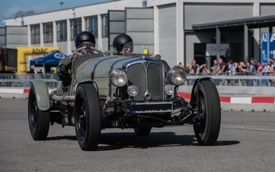 Oldtimer f&auml;hrt auf der Klassikwelt Bodensee 2026, zwei Fahrer in Helmen
