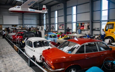 Alter Automobil-Showroom mit mehreren Fahrzeugen und einem Flugzeug in der Decke