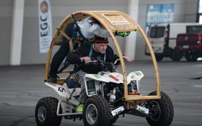 Zwei Personen fahren auf einem modifizierten ATV mit Schutzrahmen auf der Motorradwelt 2026