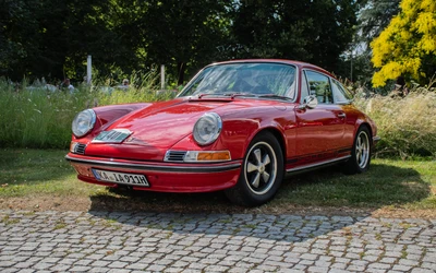 Roter Porsche 911 steht auf einem gepflasterten Weg bei der Lindau Klassik Rallye