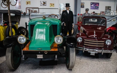 Gr&uuml;nes Oldtimer-Auto und roter Wagen in Automuseum L&ouml;mmenschwil