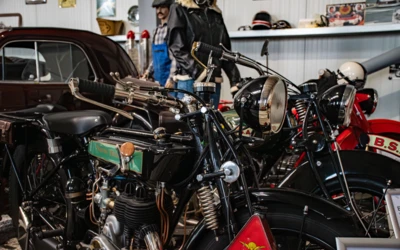 Diverse Motorr&auml;der in einem Automuseum, darunter ein schwarzes Modell mit Details