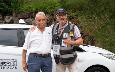 Zwei Personen posieren vor einem wei&szlig;en Fahrzeug bei der Lindau-Klassik Rallye.