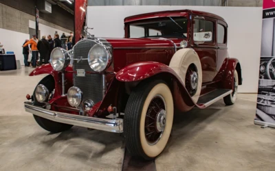 Roter Oldtimer mit wei&szlig;em Reifen in Ausstellungshalle auf Messe