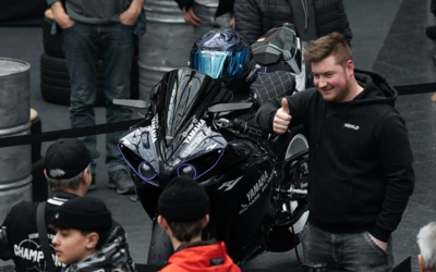 Schwarzes Motorrad Yamaha YZF-R1 auf einer Messe mit Besuchern