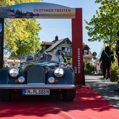 Oldtimer Treffen 2026 mit einem Morgan Roadster auf rotem Teppich.
