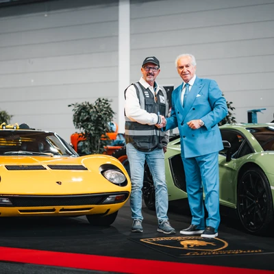 Zwei M&auml;nner sch&uuml;tteln sich die H&auml;nde neben einem gelben Lamborghini Miura auf der KLASSIKWELT BODENSEE 2026
