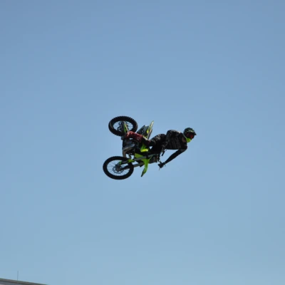 Motocross-Fahrer in der Luft mit gr&uuml;nem und schwarzem Motorrad auf der Tuning World 2025