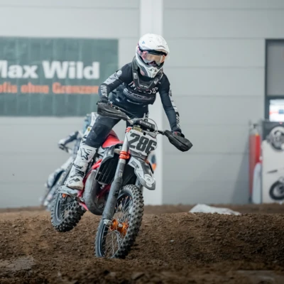 Junge Person f&auml;hrt mit einem Motocross-Motorrad auf einer Strecke bei der Motorradwelt 2026.
