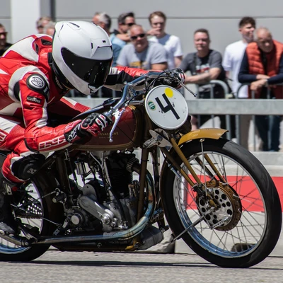 Fahrer in roter Lederkombination f&auml;hrt auf &auml;lterem Motorrad bei Klassikwelt Bodensee 2026
