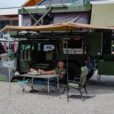 Person sitzt entspannt vor einem Wohnmobil auf der Adventure Southside 2025
