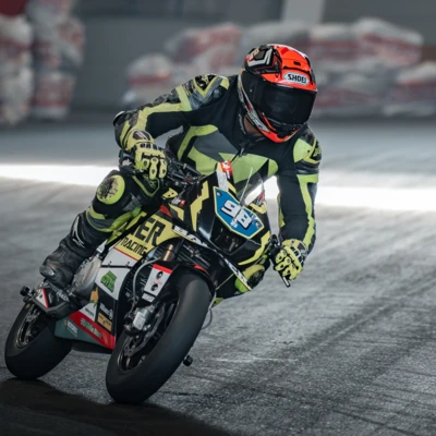 Motorradfahrer in Schutzkleidung f&auml;hrt auf einer Rennstrecke