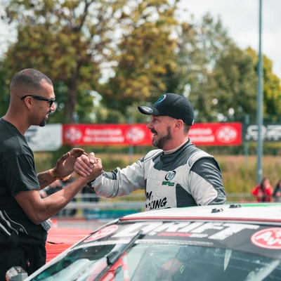 Zwei M&auml;nner sch&uuml;tteln sich nach einem Rennen bei der Tuning World Bodensee 2026