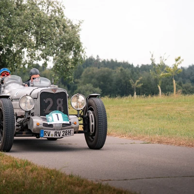 Oldtimer-Rennwagen mit der Nummer 28 auf einer Landstra&szlig;e bei der Lindau-Klassik Rallye