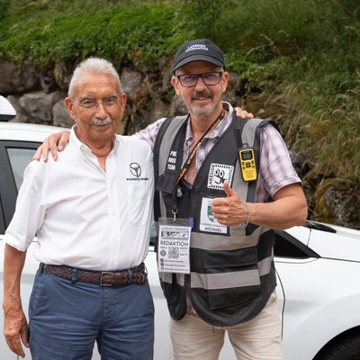 Zwei Personen posieren vor einem wei&szlig;en Fahrzeug bei der Lindau-Klassik Rallye.