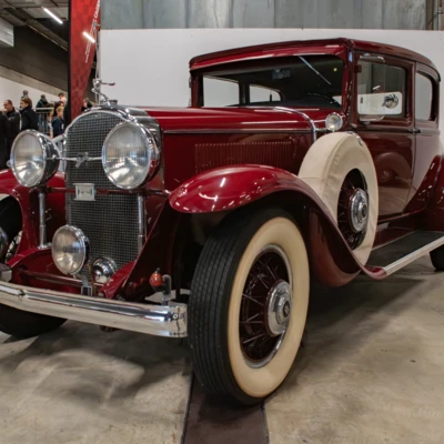 Roter Oldtimer mit wei&szlig;em Reifen in Ausstellungshalle auf Messe