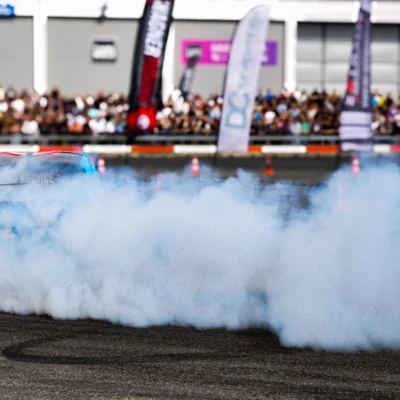 Sportwagen f&uuml;hrt Driftman&ouml;ver mit Rauchentwicklung auf der Tuning World 2025