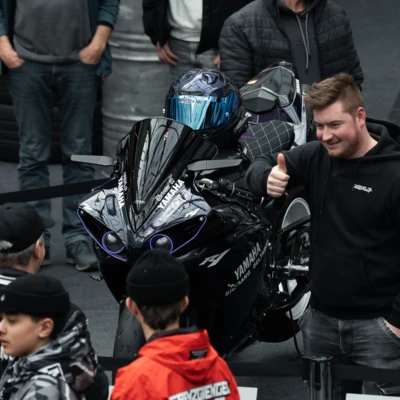 Schwarzes Motorrad Yamaha YZF-R1 auf einer Messe mit Besuchern