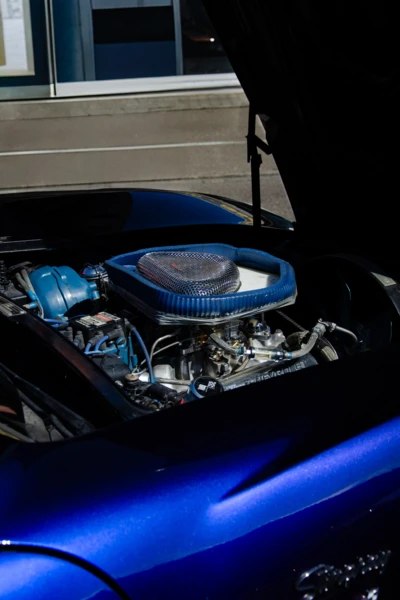 Motorraum eines blauen Autos mit sichtbarem Motor und Luftfilter