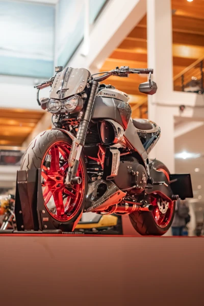 Motorrad mit roten Felgen und auff&auml;lliger Karosserie auf einer Ausstellung