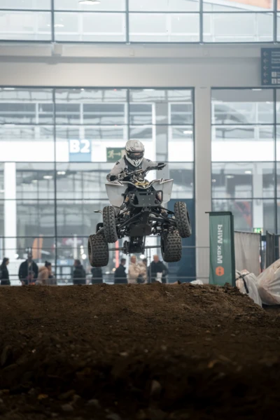 Motorradfahrer springt mit Quad &uuml;ber Erdaufwurf auf der Motorradwelt 2026