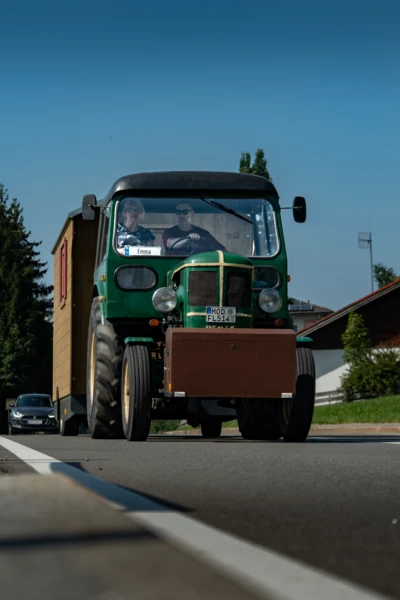 Alter Traktor mit Holzaufbau f&auml;hrt auf Stra&szlig;e beim Oldtimertreffen Langen 2025