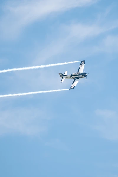 Zweimotoriges Flugzeug mit Looping am Himmel &uuml;ber Friedrichshafen