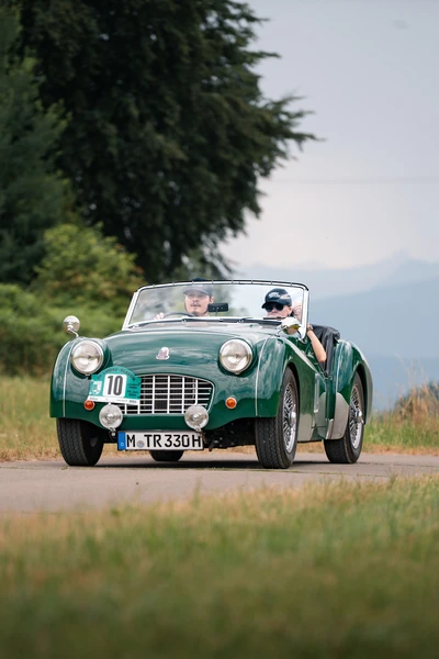 Gr&uuml;ner klassischer Sportwagen f&auml;hrt auf einer Stra&szlig;e w&auml;hrend der Lindau-Klassik Rallye.