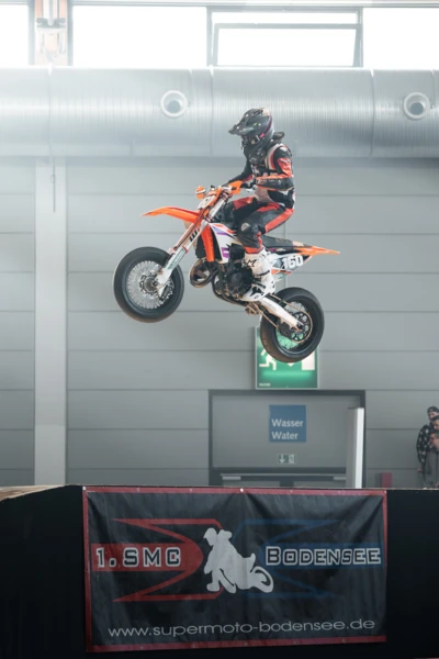 Motorradfahrer springt mit KTM in der Luft auf der Motorradwelt 2026 Messe