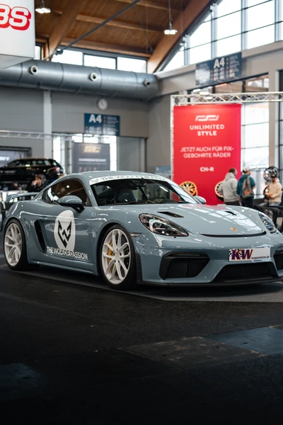 Grauer Porsche 718 Cayman mit Sponsorenlogo auf der Tuning World Bodensee 2026