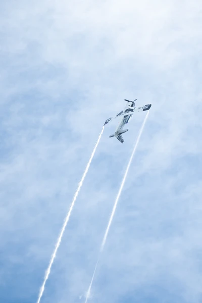 Flugzeug f&uuml;hrt Looping mit Kondensstreifen am Himmel aus