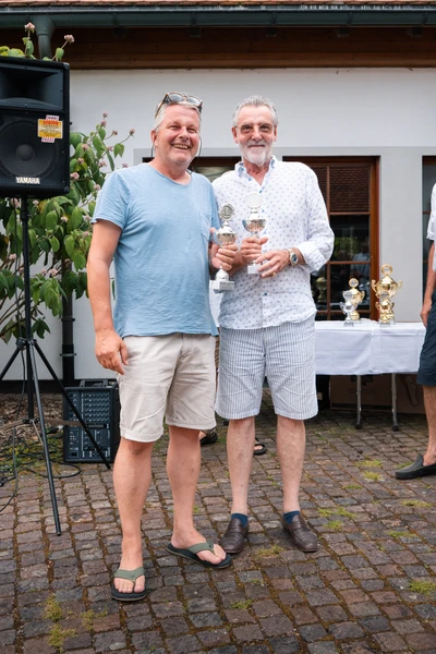 Zwei M&auml;nner halten Pokale w&auml;hrend der Lindau-Klassik Rallye