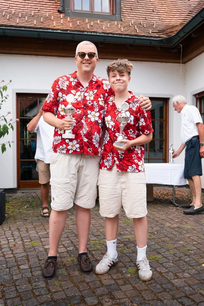 Zwei Personen in bunten Hemden halten Pokale nach der Lindau-Klassik Rallye