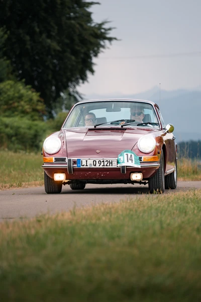 Porsche 911 in rot bei der Lindau-Klassik Rallye auf einer Landstra&szlig;e