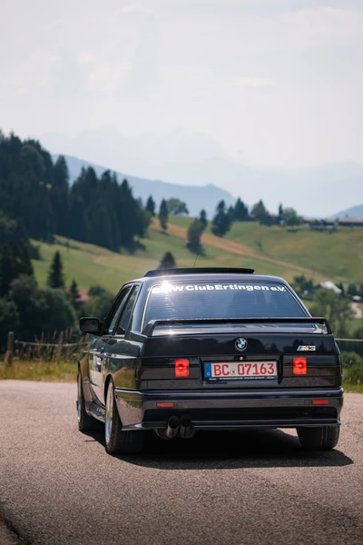 BMW M3 auf der Lindau-Klassik Rallye, idyllische Landschaft im Hintergrund
