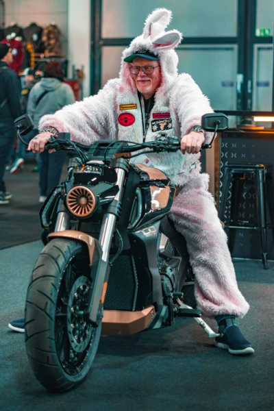Mann in einem Hasenanzug sitzt auf einem Motorrad auf der Motorradwelt 2026