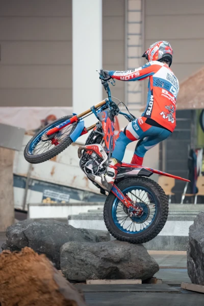 Motorradfahrer in roter und blauer Kleidung Balanciert auf Felsen bei der Motorradwelt 2026