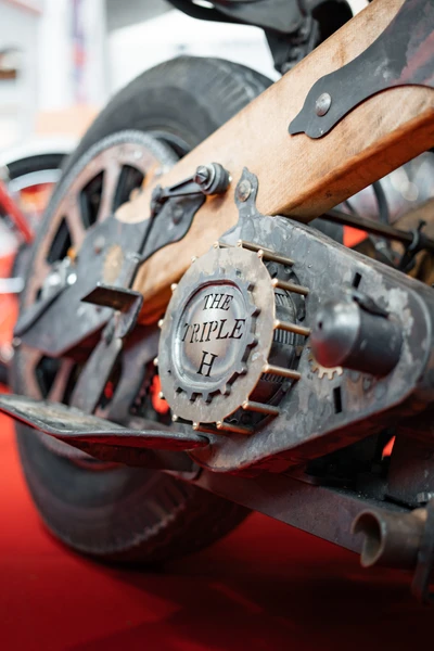 Detailaufnahme einer Custom-Motorradmaschine mit verzierten Teilen auf rotem Teppich.