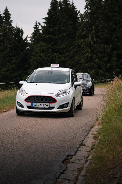 Zwei Fahrzeuge auf einer Landstra&szlig;e bei der Lindau-Klassik Rallye