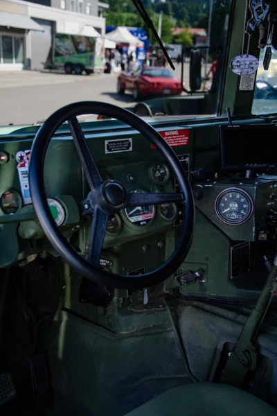 Innenansicht eines milit&auml;rischen Fahrzeugs mit gr&uuml;nem Armaturenbrett und Lenkrad