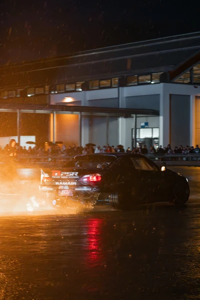 Schwarzes Driftfahrzeug mit Rauch und Wassernebel auf der Tuning World 2026.