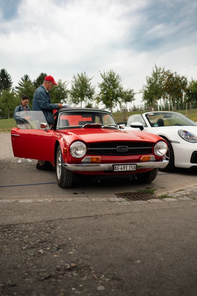 Roter Oldtimer steht neben wei&szlig;em Sportwagen auf der 10. Spa&szlig;rallye Bodensee 2026