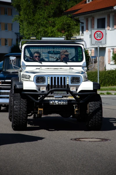 Wei&szlig;er Jeep mit gro&szlig;em Offroad-Fahrwerk auf der Stra&szlig;e in Lindenberg