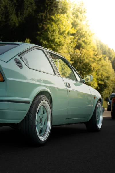 Mintgr&uuml;nes Auto auf einer Stra&szlig;e mit B&auml;umen im Hintergrund, Oldtimertreffen Langen 2025