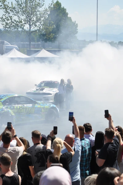 Rennwagen f&uuml;hren Driftman&ouml;ver inmitten einer Menschenmenge auf der Tuning World 2025