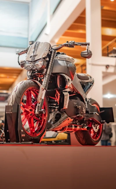 Motorrad mit roten Felgen und auff&auml;lliger Karosserie auf einer Ausstellung