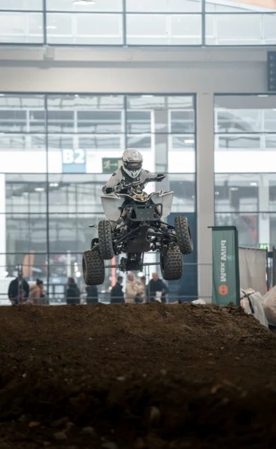 Motorradfahrer springt mit Quad &uuml;ber Erdaufwurf auf der Motorradwelt 2026