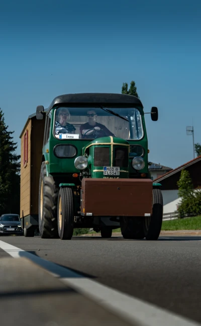 Alter Traktor mit Holzaufbau f&auml;hrt auf Stra&szlig;e beim Oldtimertreffen Langen 2025